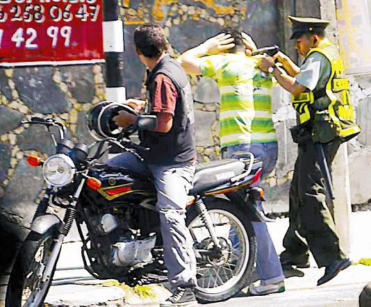 Un fotógrafo captó el momento preciso, en el cual el policía detuvo a unos de los asaltantes.