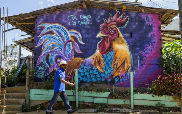 Oscar Darío Zapata camina frente a uno de los murales que decoran el barrio. FOTO JAIME PÉREZ
