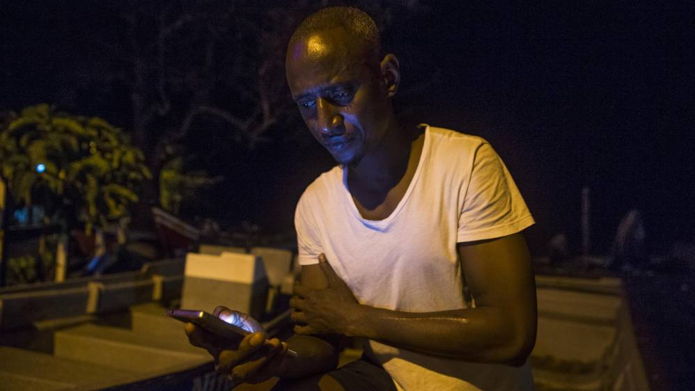 Ibrahim Muctar Jalloh de Sierra Leona lleva varios meses en Capurganá. Su única forma de comunicarse con la familia es a través de redes sociales en su celular. Pasó varios meses detenido en un campo de refugiados en Panamá donde según él tuvo que cortarse el brazo izquierdo para que lo dejaran salir. Foto: Esteban Vanegas