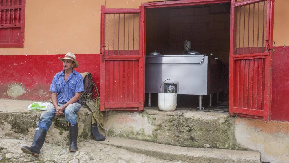 Gustavo Elías Mazo en su finca del municipio de Belmira. Atrás, el tanque de enfriamiento en el que se almacena la leche. Foto: Edwin Bustamante