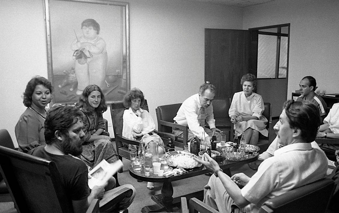 Reunión en la dirección de la Piloto. En los extremos Luis Fernando Peláez y Miguel Escobar. A la izquierda, Gloria Palomino, Tita Maya, Luz Mercedes Cadavid, María José Rodríguez. Manuel, entre todos. Foto Jairo Osorio, del libro iconográfico Manuel revelado.