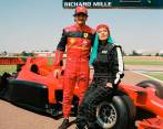 El piloto Carlos Sainz y la cantante Karol G después de recorrer en el auto una parte de la pista de Ferrari en Italia. Foto: @karolg