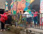 Con una masiva concurrencia, habitantes y comerciantes de la comuna 13 hicieron el aseo del Graffitour. FOTOS: CORTESÍA