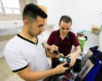 De la mano de su profesor (de negro), el estudiante Esteban Arango lidera los equipos de investigación en la IE Comercial de Envigado. Aspira a ser el mejor del planeta. FOTO esneyder gutiérrez