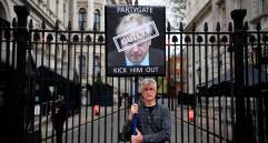 En las afueras de Downing Street, un manifestante sostiene una pancarta que señala como “culpable” a Johnson. Oposición pide renuncia del primer ministro británico. FOTO EFE