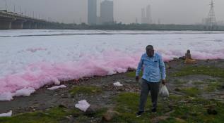 Un hombre camina a orillas del río Yamuna cubierto de espuma tóxica. Foto: Getty