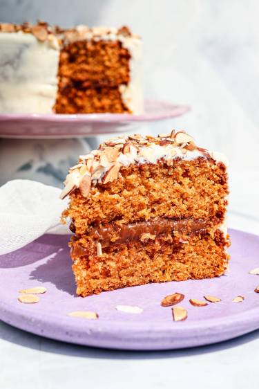  Torta de zanahoria rellena de arequipe y cubierta con crema de cheesecake de limón y almendras. Foto cortesía.