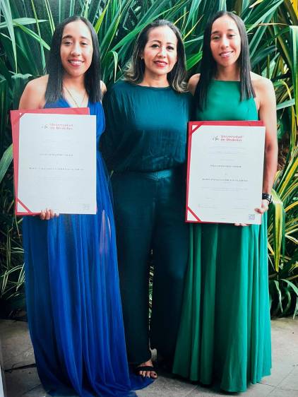 Paula y Valentina junto a su mamá recibiendo el título de la Universidad de Medellín. FOTO CORTESÍA 