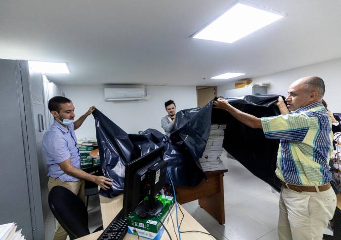 Cuando comienza a llover las labores se detienen mientras los funcionarios cubren con plástico sus elementos de trabajo. FOTO CAMILO 