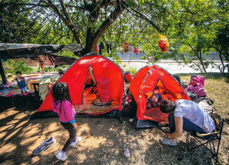 La familia acampa junto a un grupo de otros 40 migrantes, que se quedaron varados a la orilla del río Medellín. FOTO: ESNEYDER GUTIÉRREZ