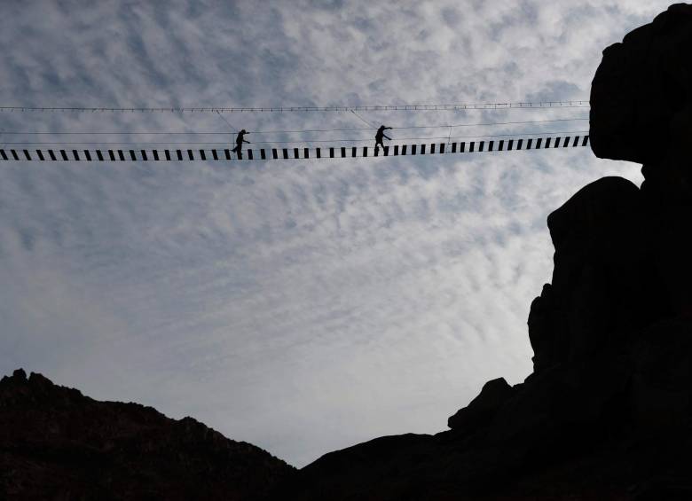 El puente colgante de tablas se encuentra en lo alto de un cerro desde el que se divisan miles de casas. Foto: EFE