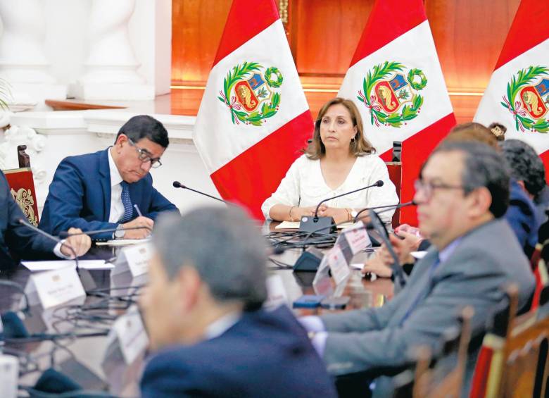 La presidenta del Perú, Dina Boluarte, lidero una reunión de su equipo para analizar salidas a la crisis que ya deja 28 muertos. Y en Ayacucho (al lado) familiares de una de las víctimas lo despiden. FOTOS Efe