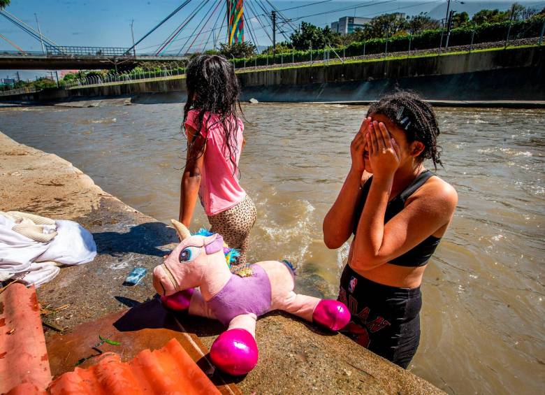 Pese a estar contaminada, el agua del río Medellín le recuerda a los hijos de Yonatan y Albany sus días felices en Isla de Margarita. FOTO: ESNEYDER GUTIÉRREZ