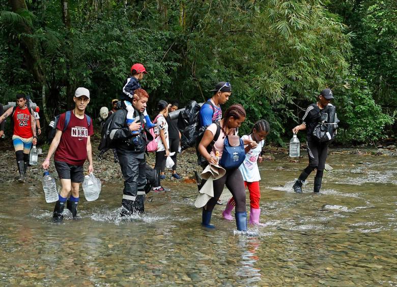Migrantes atraviesan un río con la intención de llegar a Panamá. FOTO: EFE