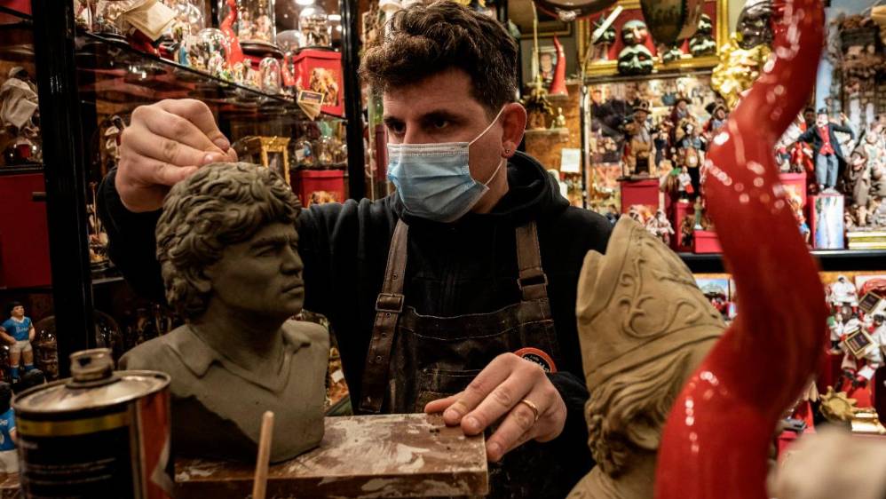 Un joven artesano de San Gregorio Armeno (Maestro de la Natividad) trabaja en un busto de Maradona en su taller. Foto: Getty Images.