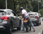 El hombre armado se acerca en la motocicleta a la camioneta que es su víctima. FOTO: Cortesía