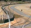 Una palestina camina junto a una valla de seguridad construida para separar a Israel de Cisjordania. FOTO REUTERS