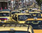Una caravana de 600 taxistas recorrió ayer las calles del centro de Medellín, en protesta por el servicio Uber. FOTO Róbinson Sáenz