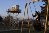 Unos niños juegan en un parque junto a una valla que marca la zona de amortiguación de las Naciones Unidas en un sector parcialmente restringido en la parte Turcochipriota del centro de Nicosia, en una imagen tomada el 15 de marzo de 2014. En Chipre, los griegos étnicos viven en el sur, los turcos en el norte. FOTO REUTERS
