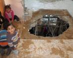 La casa de la familia Nusier, en la Franja de Gaza y los hijos de Khalil y Shaam entre las huellas que dejó el proyectil. La amenaza es latente para todo un vecindario que clama para que las autoridades desactiven el obús. FOTOS KHALED ALASHQAR