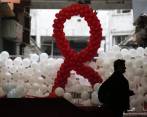 Un peatón camina frente a unos globos dispuestos para formar una cinta como parte de un evento de concientización del Día Mundial del SIDA en Atenas, Grecia. Las autoridades de salud en Grecia dicen que el número de infecciones por VIH se redujo en 2013 por primera vez desde el inicio de la crisis financiera. FOTO AP