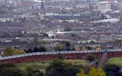Otra sección del Muro de la Paz que divide las comunidades católicas y protestantes corta su camino a través de West Belfast, el 3 de octubre de 2014. FOTO REUTERS