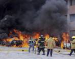 Momento en el que los bomberos intentan controlar el incendio de media docena de automóviles parqueados en el Congreso de Guerrero. FOTO AP