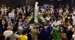 Fieles con mascarillas llevan una estatua de la Virgen María durante la misa dominical frente a un número reducido de fieles, debido a las medidas sanitarias, en la Basílica de San Pío X. FOTO AFP