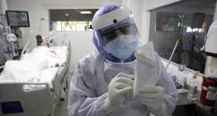 El terapeuta respiratorio escribe una nota después de tratar a un paciente infectado con Covid-19 en la Unidad de Cuidados Intensivos (UCI) de la Clínica CES en Medellín. FOTO AFP