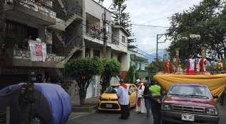 En el Barrio La Milagrosa, de la comuna 9 de Medellín, la iglesia organizó una procesión solitaria donde imparte la palabra acompañada de la policía. Los feligreses salen a los balcones al paso de la procesión. Foto: Edwin Bustamante.