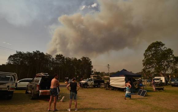 Miles de australianos que tuvieron que dejar sus casas por los incendios se encuentran atrapados en campamentos improvisados en campos de golf o playas, convirtiéndose así en refugiados en su propio país. FOTO AFP