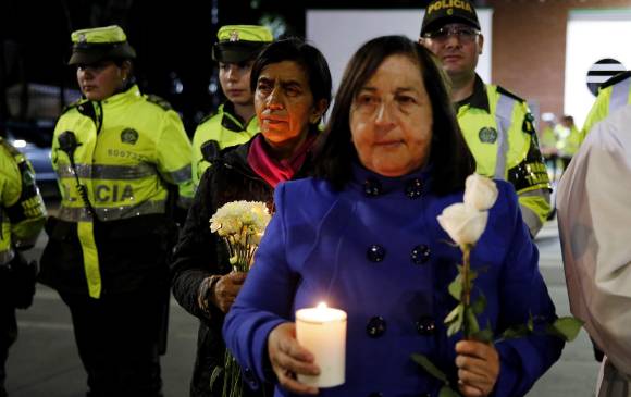 Ciudadanos y policías participan en un plantón este jueves frente a la Escuela de Cadetes de Policía General Francisco de Paula Santander, en Bogotá. FOTO EFE