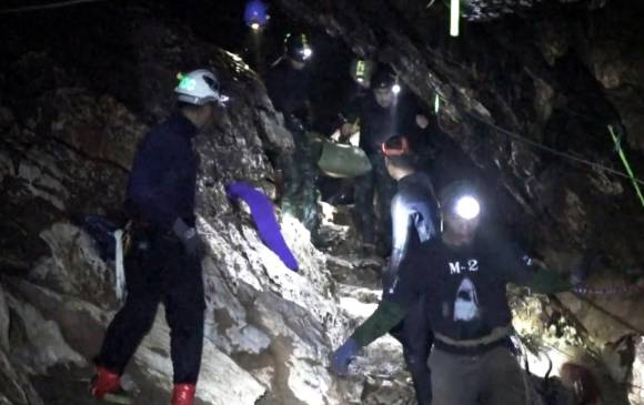 Varios miembros del equipo de rescate evacuan a un niño atrapado en la cueva Tham Luang, en Chiang Rai (Tailandia) Foto: EFE
