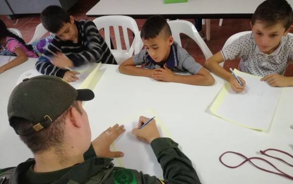 Todos los viernes a las 3 de la tarde, el patrullero de la Policía Guzmán se reúne con los estudiantes de la escuela del corregimiento de Otaré para darles clases de dibujo. FOTOs cortesía