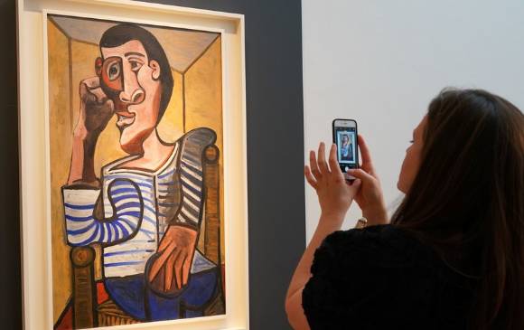Una empleada de Christie’s fotografía ‘El marinero’, de Pablo Picasso, el pasado 3 de mayo en la casa de subastas, en Nueva York. Foto: AFP