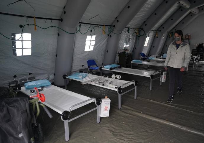 Las camas se alinean en una tienda de campaña mientras los voluntarios establecen un hospital de campaña de emergencia para los pacientes que sufren del coronavirus en Central Park, frente a la Quinta Avenida. Foto: AFP