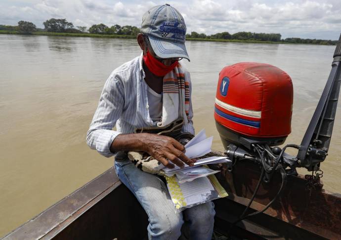 Por la falta de acceso a internet y las restricciones por la cuarentena en zonas apartadas del municipio de Caucasia, se activó el sistema de comunicación a través de cartas. Don José Zambrano con el apoyo de Comfenalco, asumió la misión de llevar y traer la misivas y repartirlas de casa en casa. Foto: Manuel Saldarriaga Quintero.