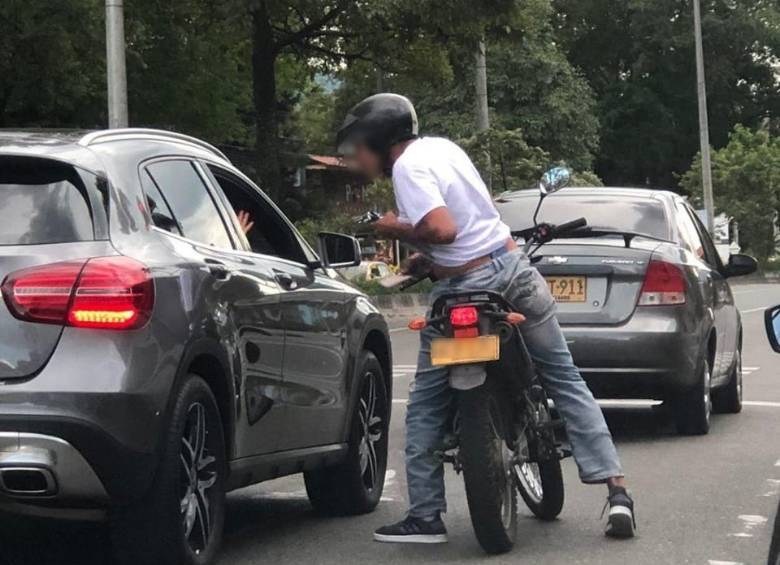 El hombre armado se acerca en la motocicleta a la camioneta que es su víctima. FOTO: Cortesía