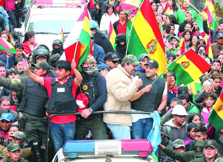 Ciudadanos y policías celebran la renuncia de Evo en La Paz. Los uniformados se habían atrincherado durante la semana para pedir la renuncia del ahora expresidente. FOTO EFE