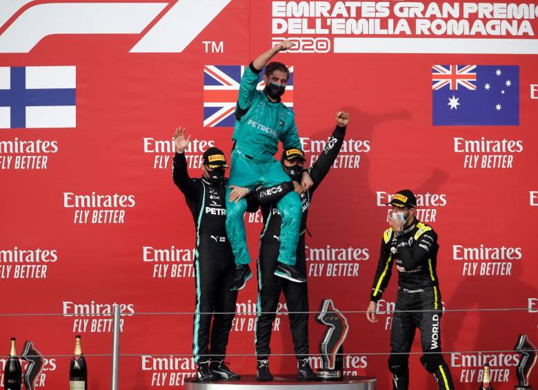 Lewis Hamilton y Valtteri Bottas celebran con miembro de Mercedes el campeonato de constructores. FOTO AFP