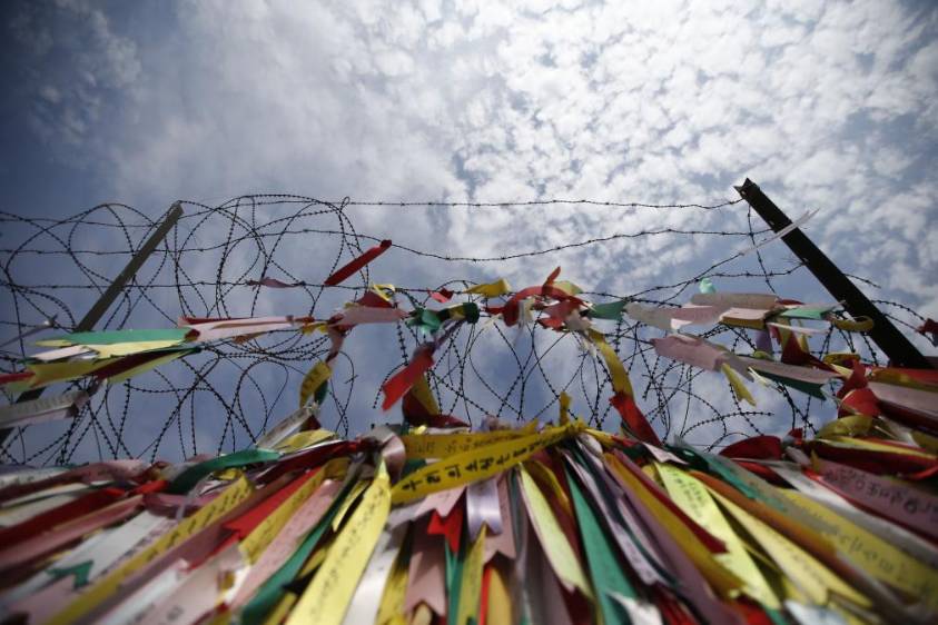 La cerca de alambre de púas está decorada con cintas multicolores que contienen mensajes escritos que desean la unificación de las dos Coreas, cerca la zona desmilitarizada que las separa en Paju, en esta foto tomada el 31 de octubre 2014. FOTO REUTERS