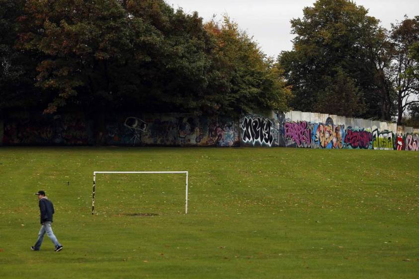 El Muro de la Paz corta su camino a través del Parque Alexandra, en el norte de Belfast. Imagen tomada el 3 de octubre de 2014. Hechos de piedra y metal, con alambres de espinos y cámaras de vigilancia, sirven para segregar a protestantes y católicos. FOTO REUTERS