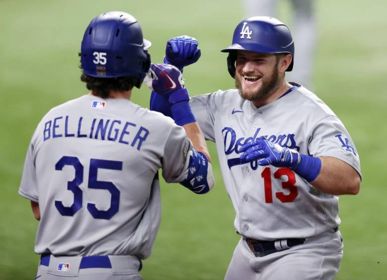 Max Muncy (13) congratula a Cody Bellinger por su cuadrangular frente a los Rays que contribuyó a la victoria 4-2 este domingo en la Serie Mundial. Foto AFP