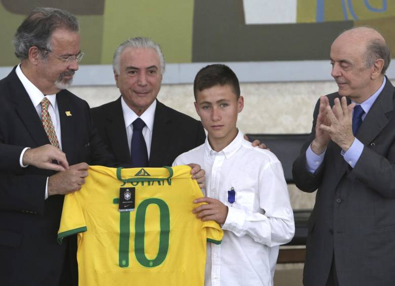 Momento en el que Johan Alexis Ramírez recibe la camiseta de la Selección de Brasil con su nombre y el número 10. Lo acompañan: Raul Jungmann, ministro de Defensa de Brasil; Michel Temer, presidente de Brasil; y Jose Serra, canciller de Brasil. FOTO ap