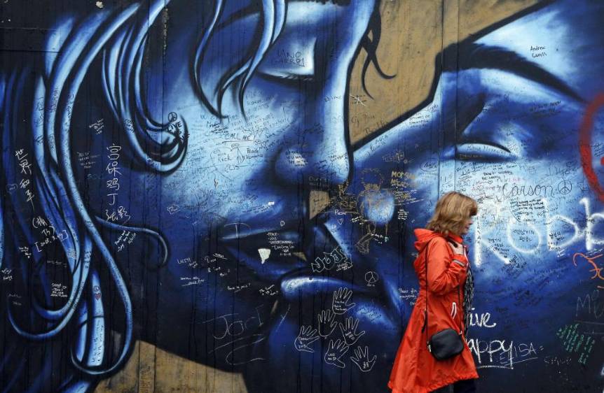 Una turista camina al frente de una sección del Muro de la Paz en el oeste de Belfast, el 3 de octubre de 2014. Se extienden a lo largo de 20 kilómetros y miden a veces más de siete metros de alto. FOTO REUTERS