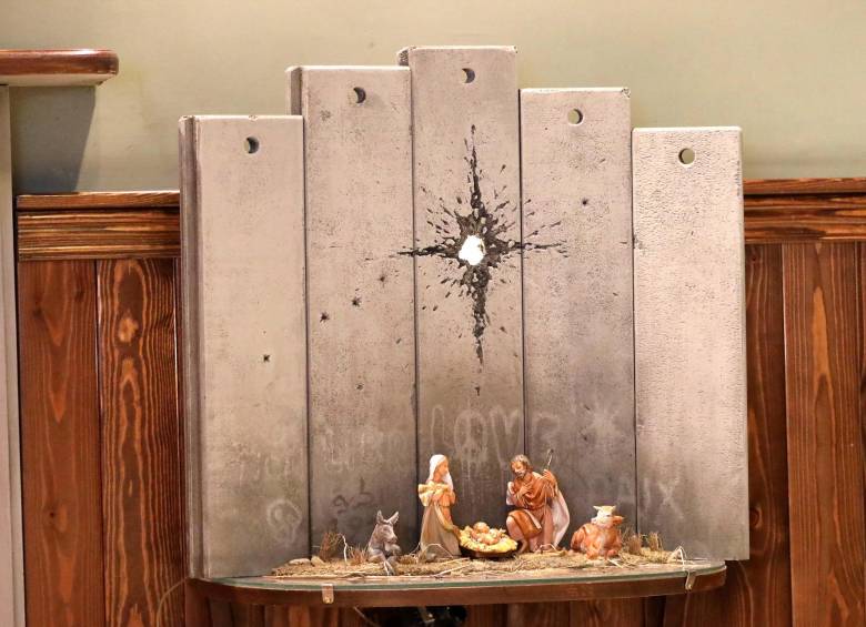 El hotel del artista británico Banksy en la ciudad palestina de Belén acoge estas navidades un singular nacimiento, en el que José, María y el niño Jesús tienen de telón de fondo el imponente muro israelí con un impacto de proyectil con forma de estrella. Foto: EFE