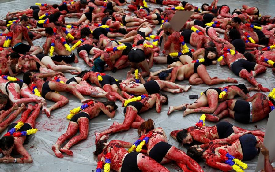 Tendidos en el suelo, alrededor de 200 hombres y mujeres, que vestían únicamente un calzón negro, fueron rociados con tinta roja. En sus espaldas fueron acondicionadas banderillas con los colores de la bandera colombiana, para enfatizar en que el país “no quiere que se haga un espectáculo de la muerte”. FOTO REUTERS 