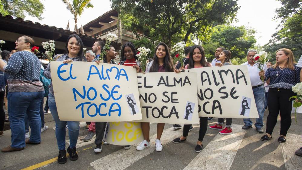 Flores y pancartas fueron llevados por la comunidad universitaria en un acto simbólico para rechazar los actos violentos.