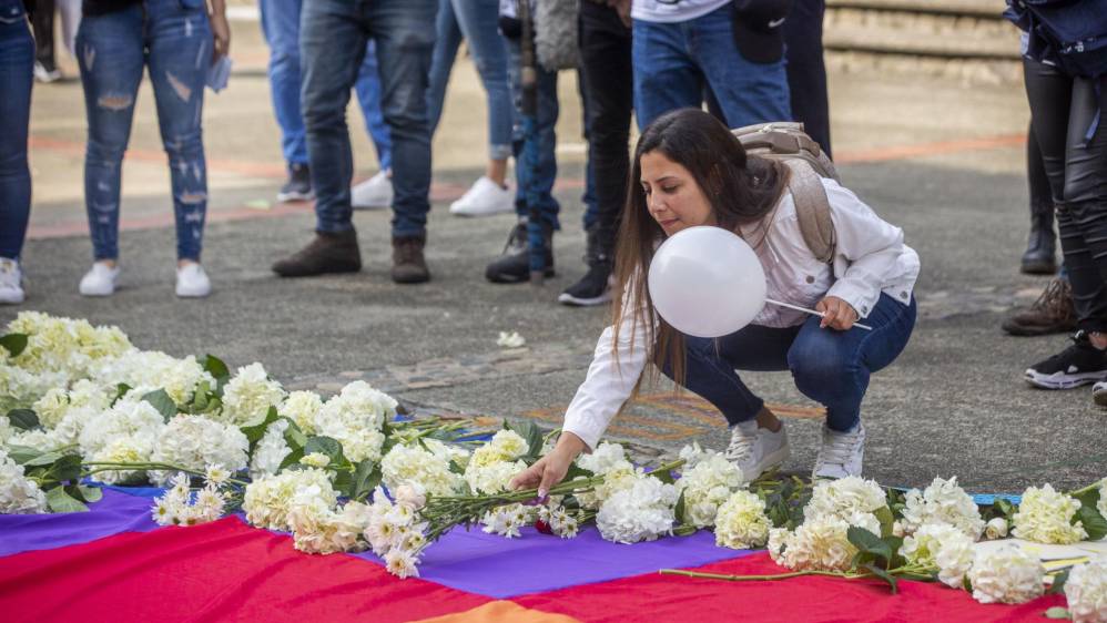 Flores y pancartas fueron llevados por la comunidad universitaria en un acto simbólico para rechazar los actos violentos.